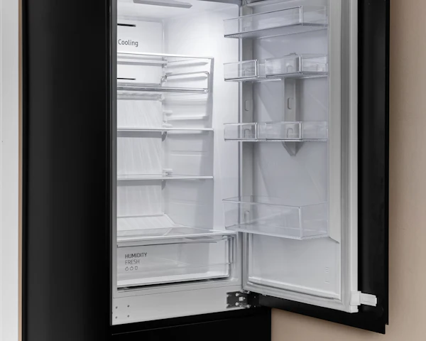 Built-in refrigerator with its door open, showing the shelves and door bins